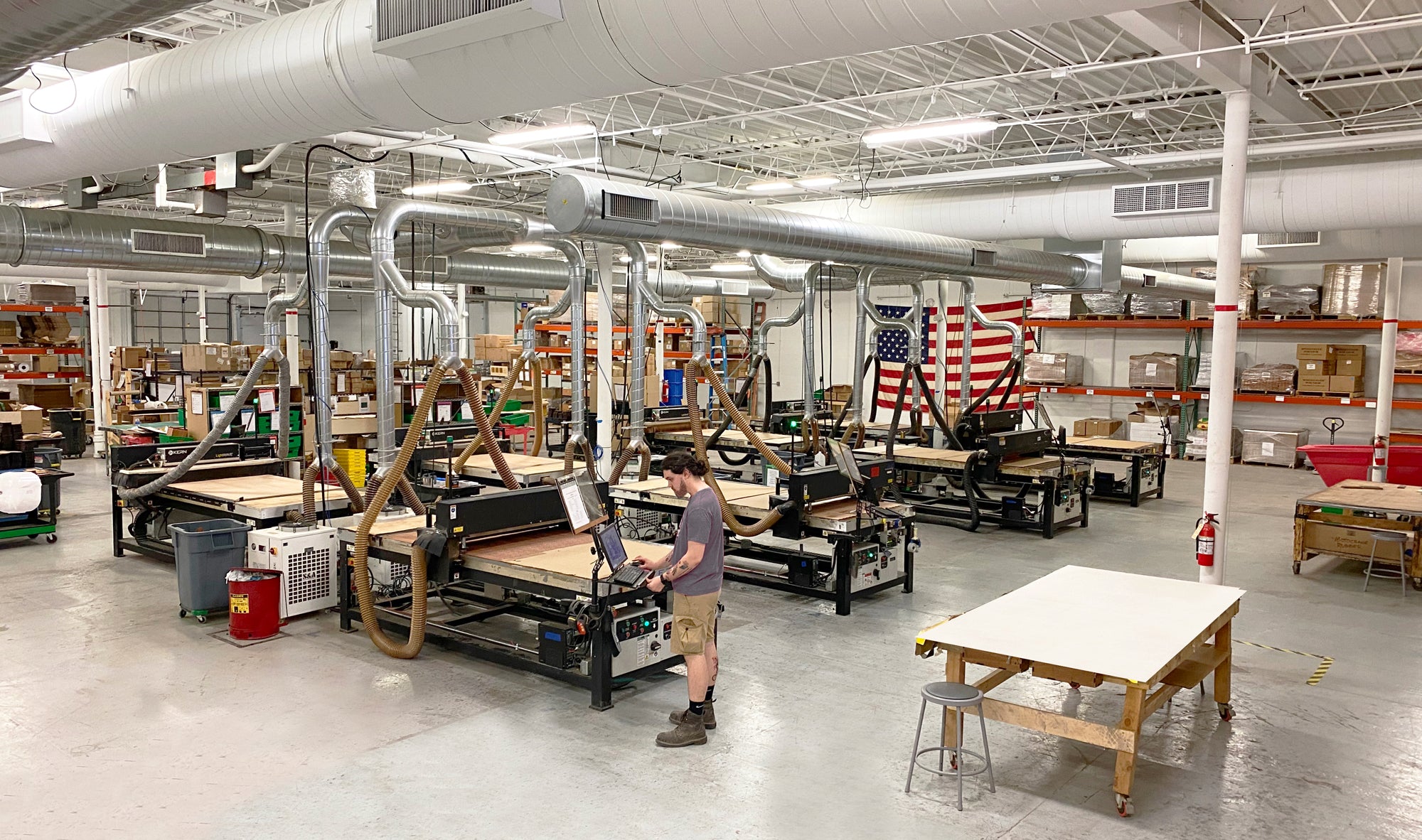 WOODCHUCK USA manufacturing facility in Minneapolis with CNC machines, production equipment, and American flag.
